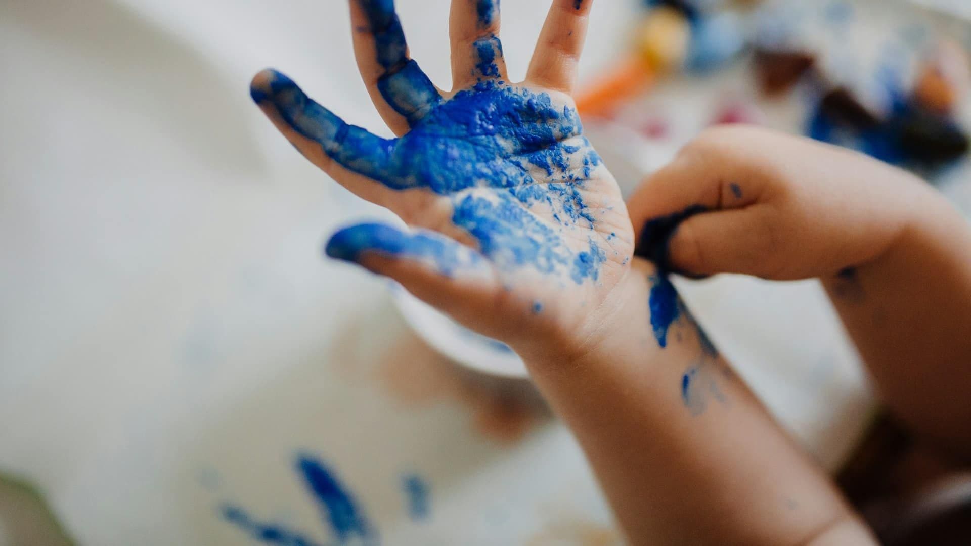 Handen met blauwe verf